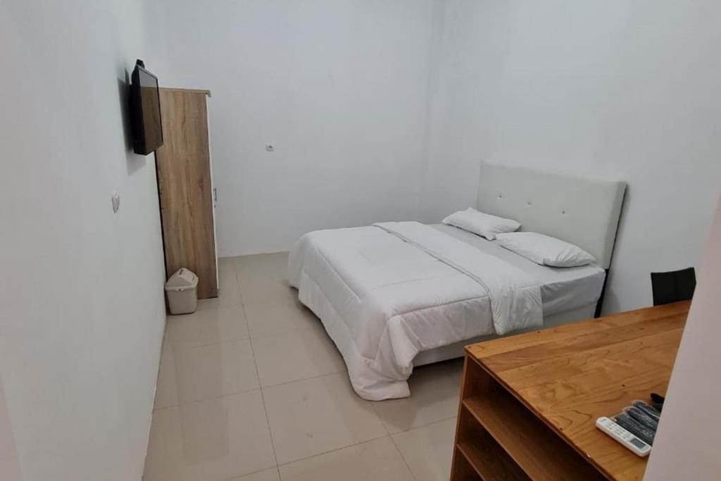 Postel nebo postele na pokoji v ubytování Krisan Guest House Syariah Banjarbaru Mitra RedDoorz