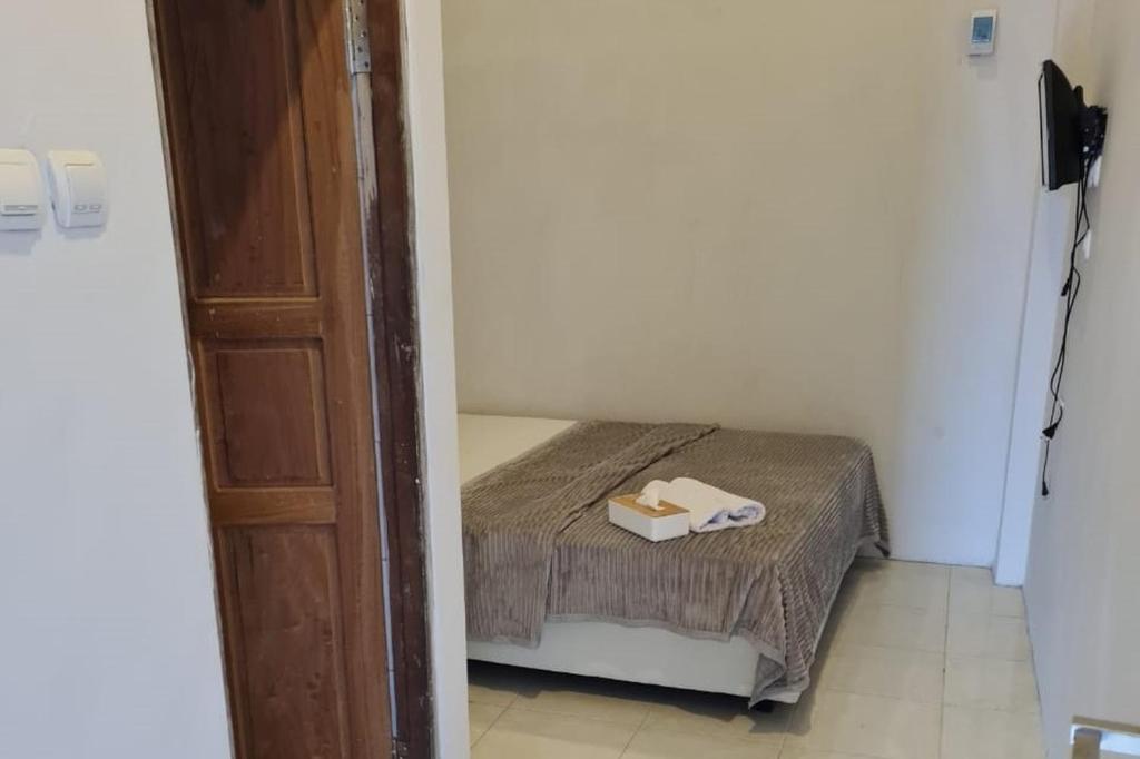 Postel nebo postele na pokoji v ubytování Krisan Guest House Syariah Banjarbaru Mitra RedDoorz