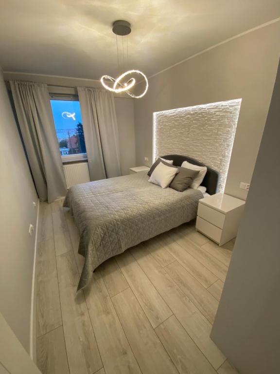 a bedroom with a large bed and a window at Flat4You II in Poznań