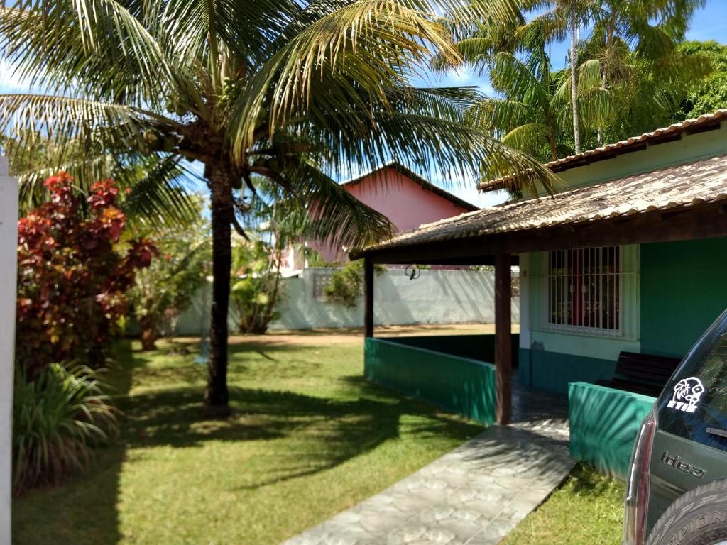 a house with a palm tree in the yard at Recanto Verde Araruama in Araruama