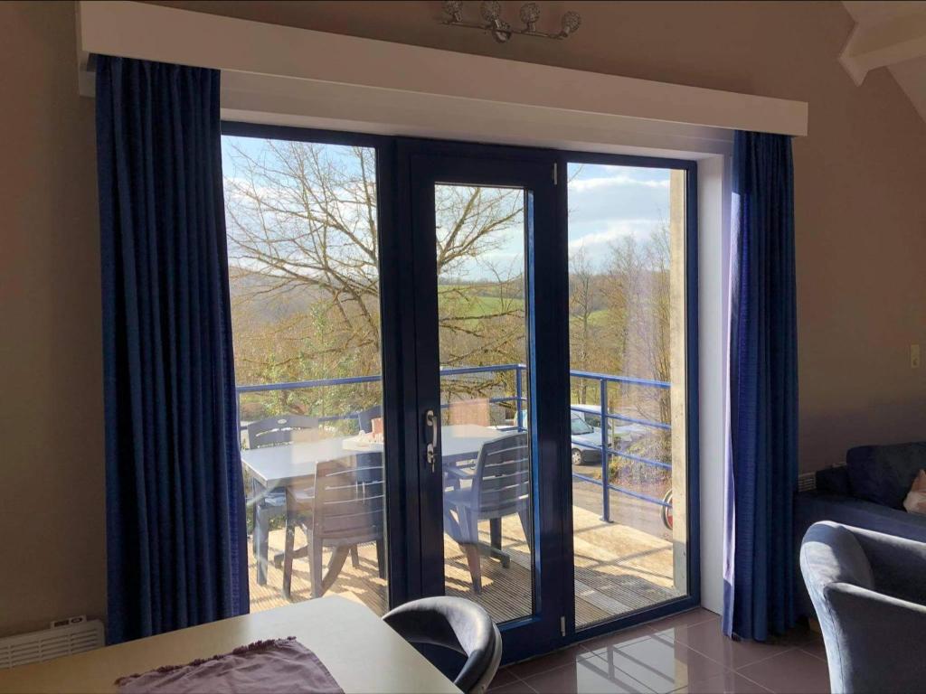 a living room with a sliding glass door with a table at Enjoy Durbuy 1 in Durbuy