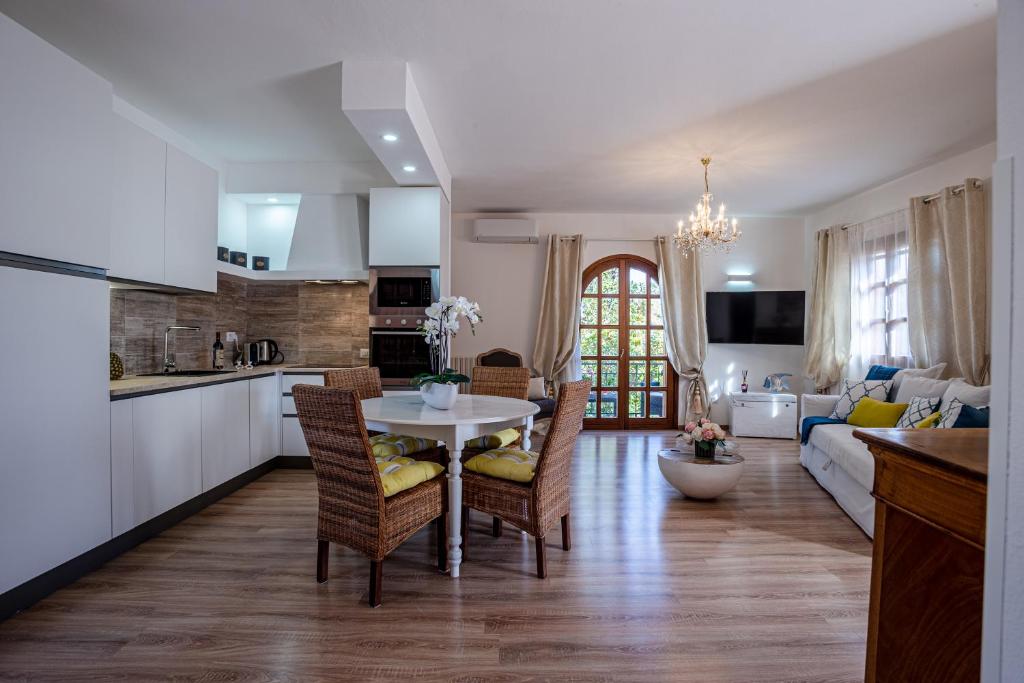 a kitchen and living room with a table and chairs at Appartamento San Teodoro centro in San Teodoro