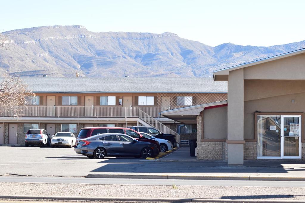 a building with cars parked in a parking lot at Satellite Inn in Alamogordo