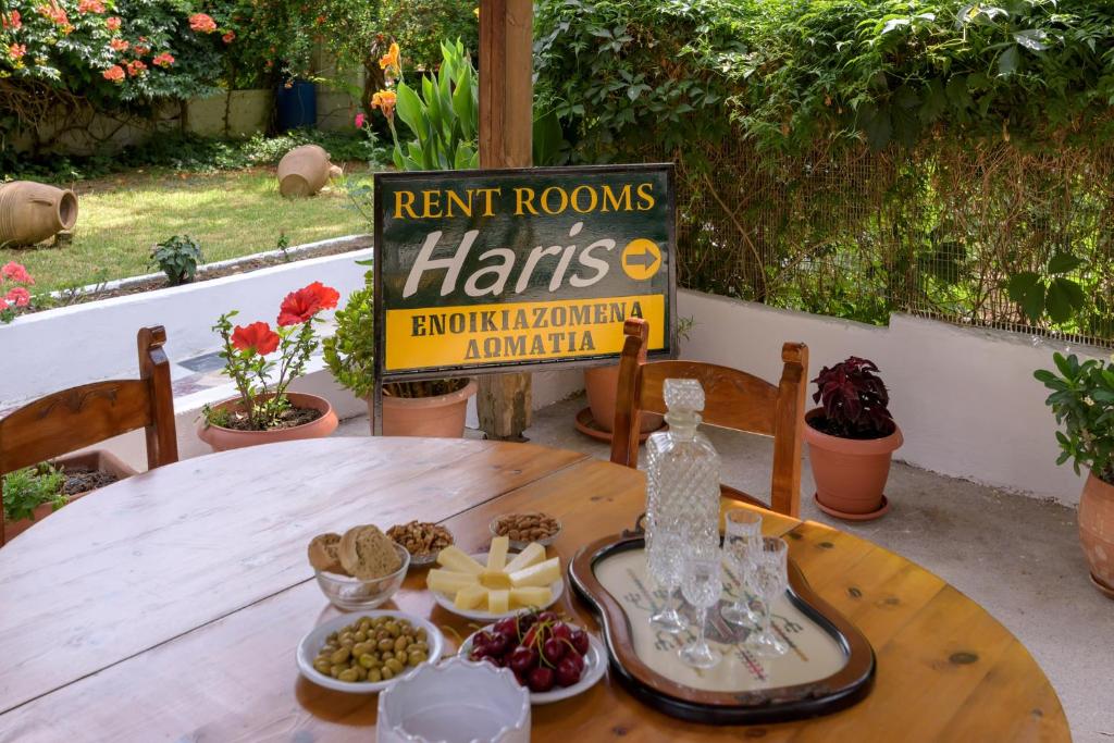 a wooden table with a sign and food on it at Haris Rooms in Georgioupolis