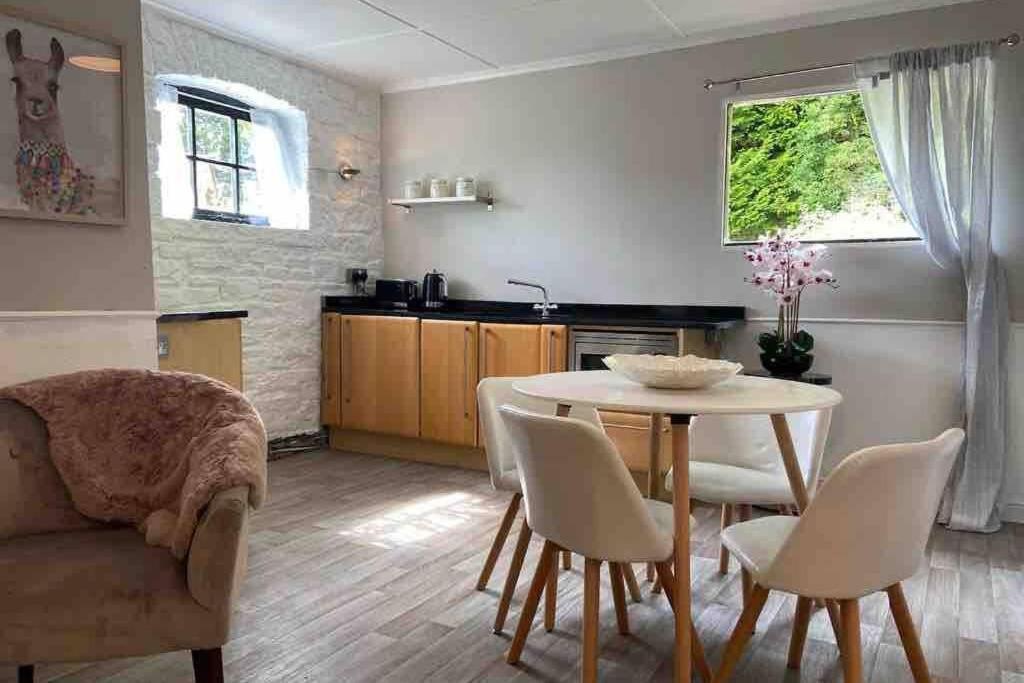 a kitchen and dining room with a table and chairs at Coach House in Keighley