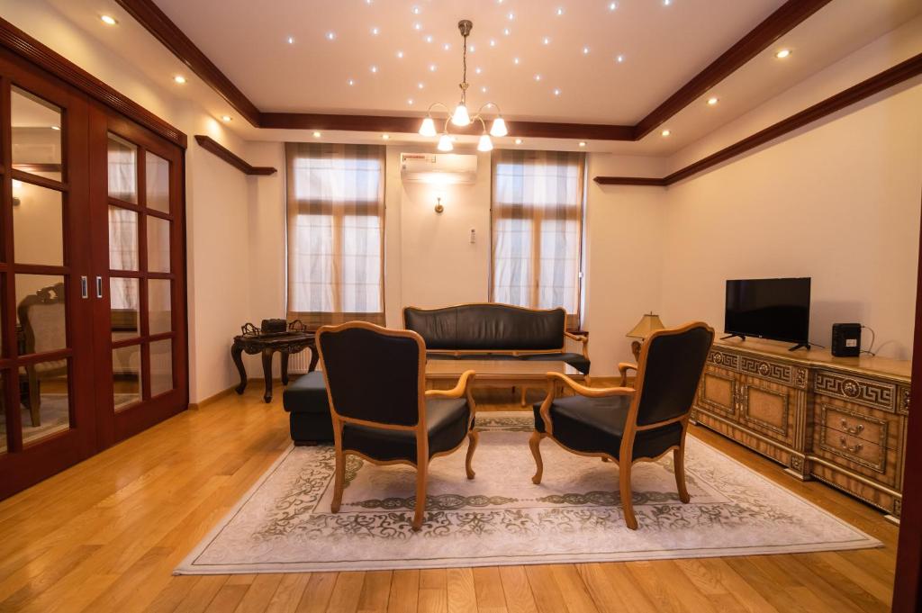 ein Wohnzimmer mit einem Sofa, einem Tisch und Stühlen in der Unterkunft Heart of Ferhadija in Sarajevo