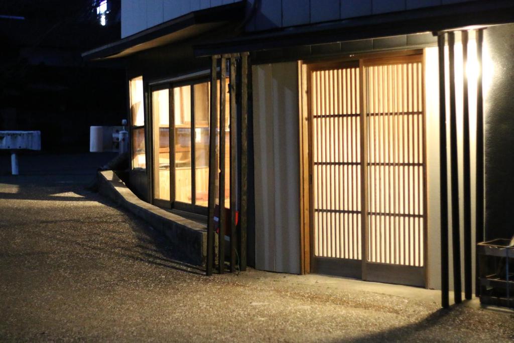 un edificio con puertas al lado de una calle en 阿蘇び心 Asobi Gokoro, en Aso