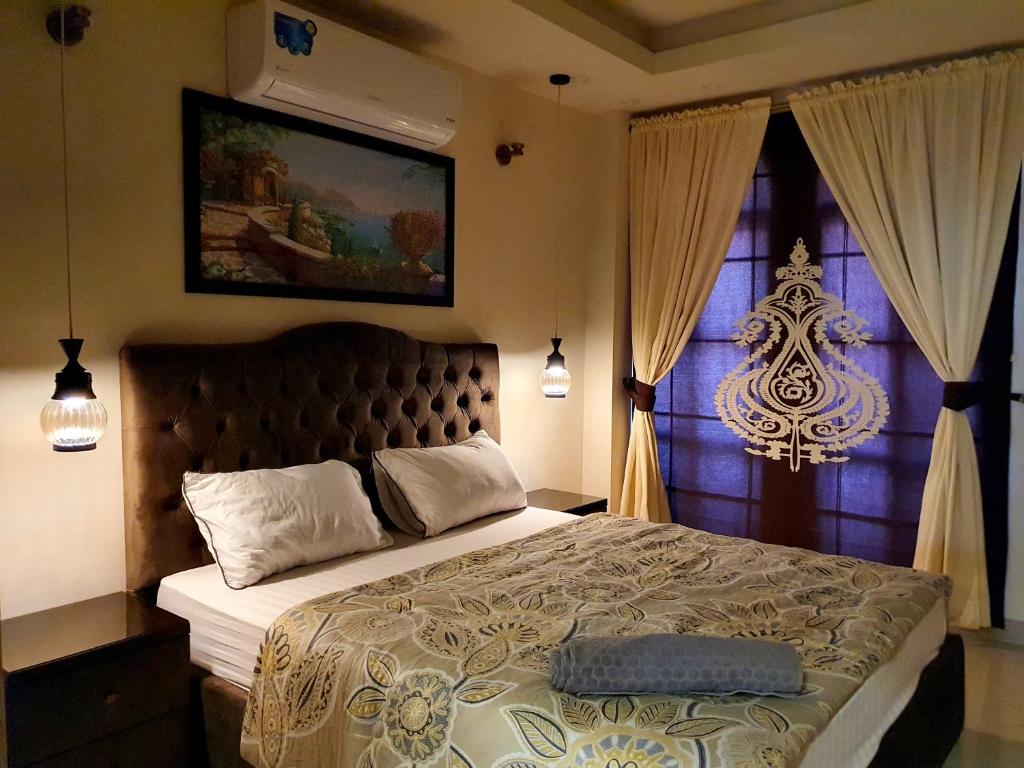 Un dormitorio con una cama grande y una ventana en The Millenial Apartments & Suites Bahria Town, en Rawalpindi