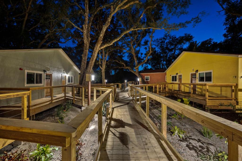 una pasarela de madera que conduce a dos edificios por la noche en Sea Cottages of Amelia en Fernandina Beach