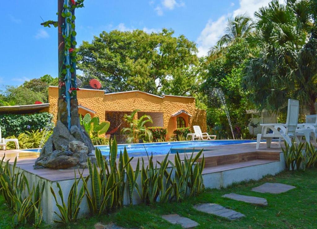 a house with a swimming pool next to a resort at Eco Hostal Kuima in El Zaino