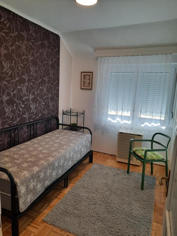 1 dormitorio con 1 cama y 1 silla en Eszterlánc Apartman Eger, en Eger