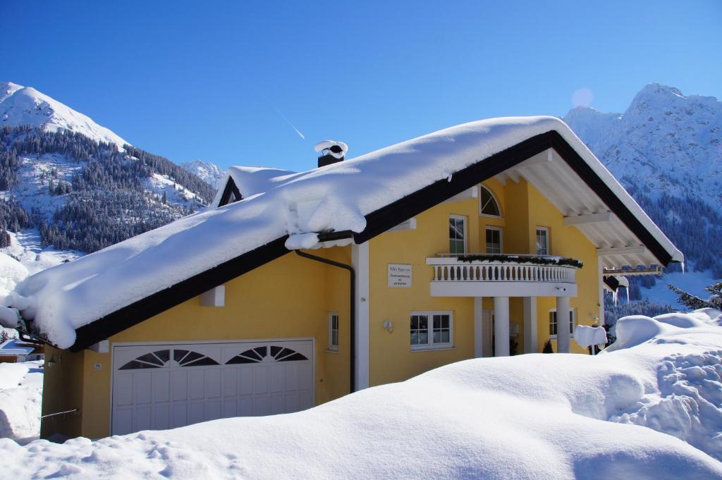 a snow covered roof of a house with a garage at Villa Vanessa Kleinwalsertal in Mittelberg