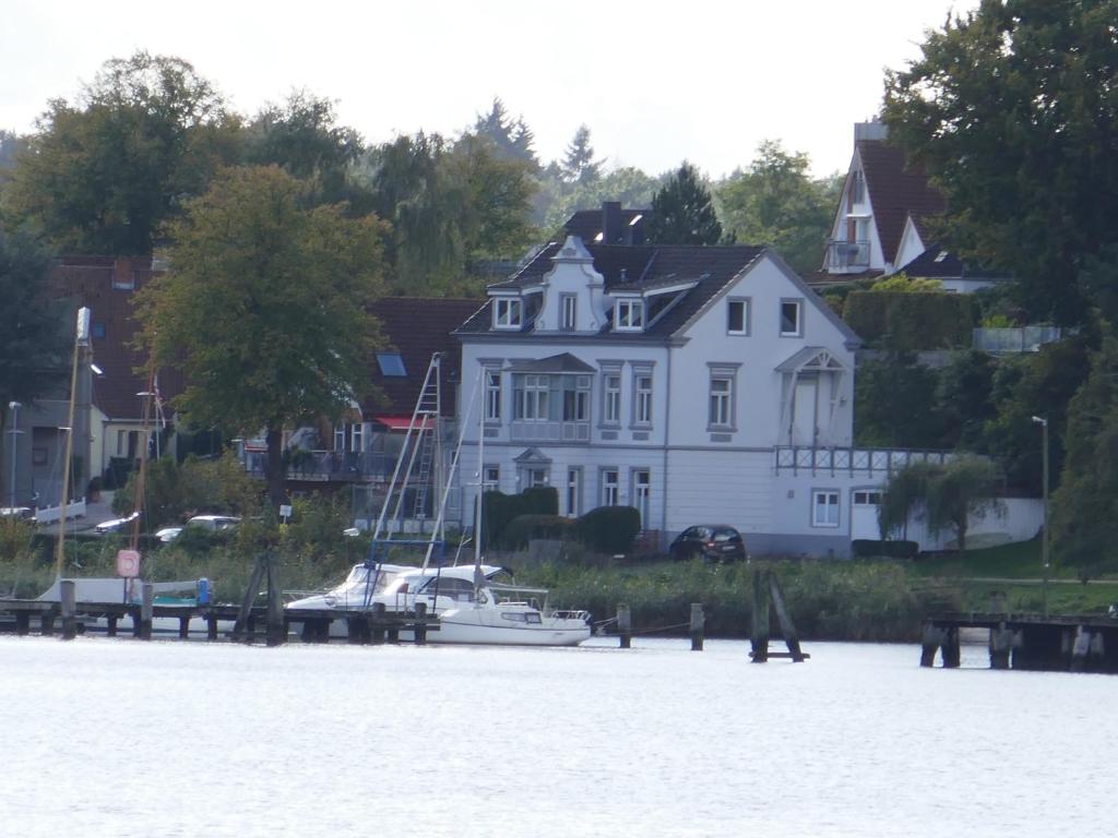 een groot wit huis met een boot in het water bij Wohnen am Seglerhafen mit Traveblick im Kontorhaus viele Extras in Lübeck