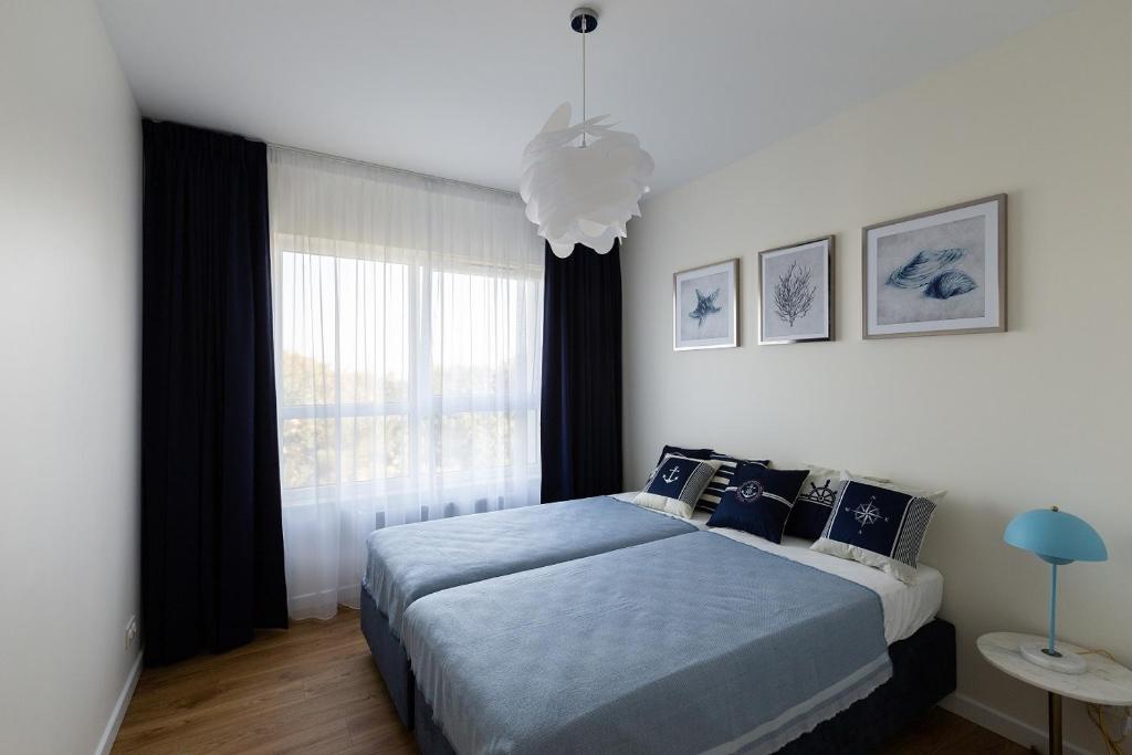 una camera con letto e finestra di JPapartments Blue przy plaży a Danzica