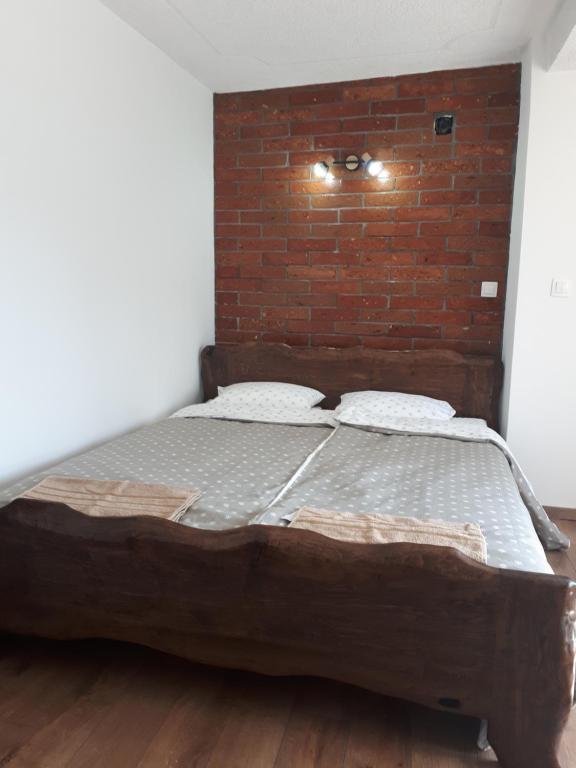 a bed in a room with a brick wall at OPG DIJANA in Kopačevo