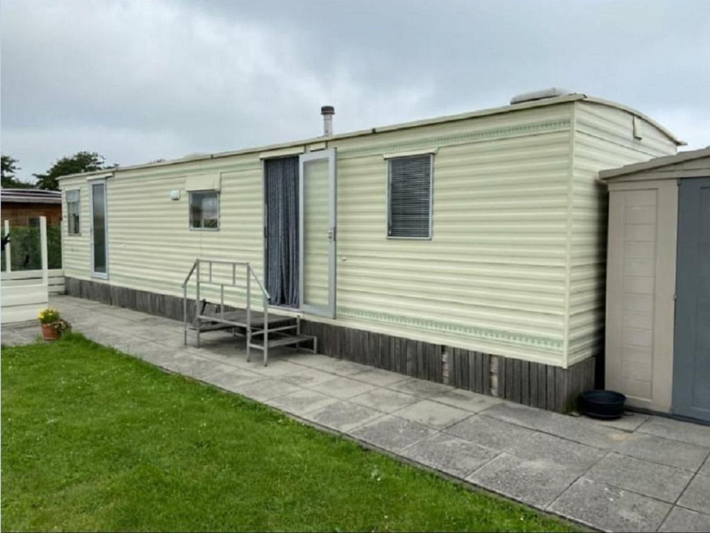 a green and white mobile home with a patio at Inviting Mobile Home in Auw near Lake, City Centre in Auw