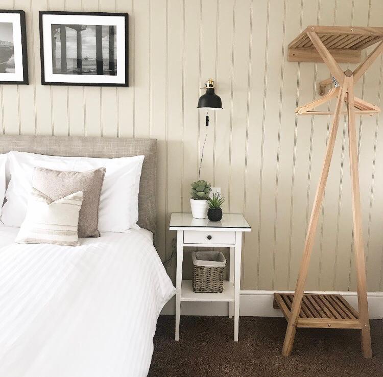 een slaapkamer met een bed en een bijzettafel met een plant bij Glenthorne Guest House in Tenby