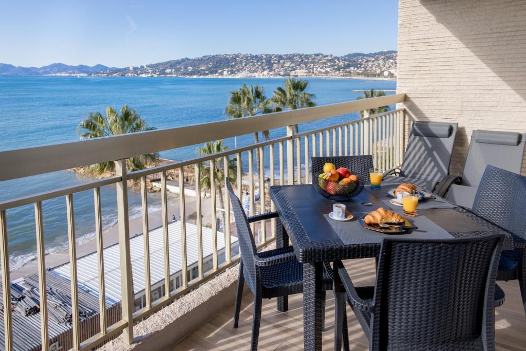 a table with a bowl of fruit on a balcony with the beach at Vue Mer Panoramique, Clim, Balcon et Plages in Antibes