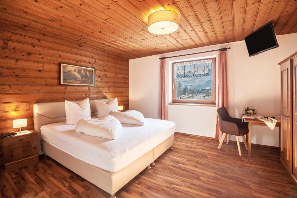a bedroom with a bed and a window and a desk at Ferienwohnung Brugger 6 Personen in Kaltenbach