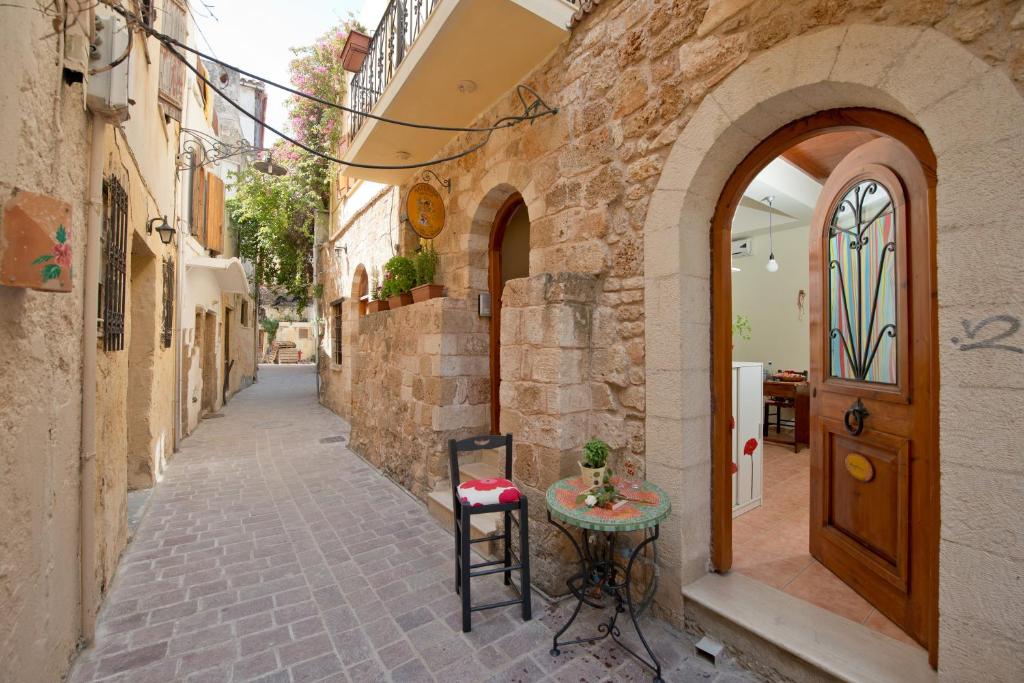 un piccolo vicolo con tavolo e porta di Katerina Traditional Rooms a Chania