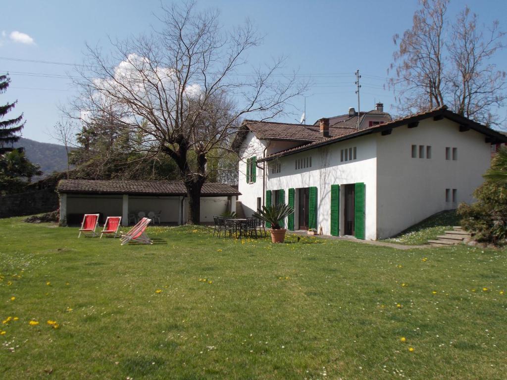 uma casa branca com cadeiras num quintal em Casa Bianchi em Rovio