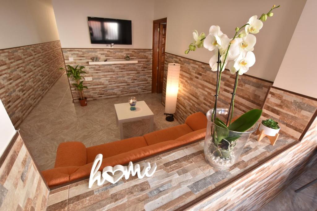 een woonkamer met een bank en bloemen in een vaas bij Casa Colmena in Arinaga