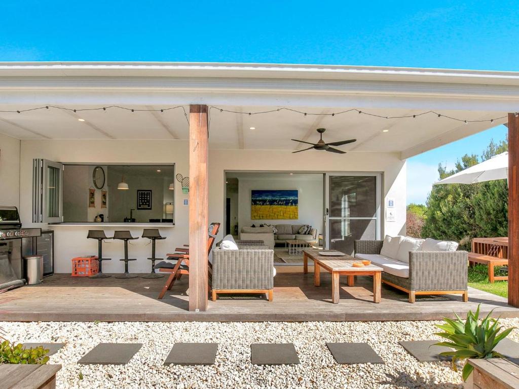 a patio with a couch and a table at Blue Waves in Smiths Beach