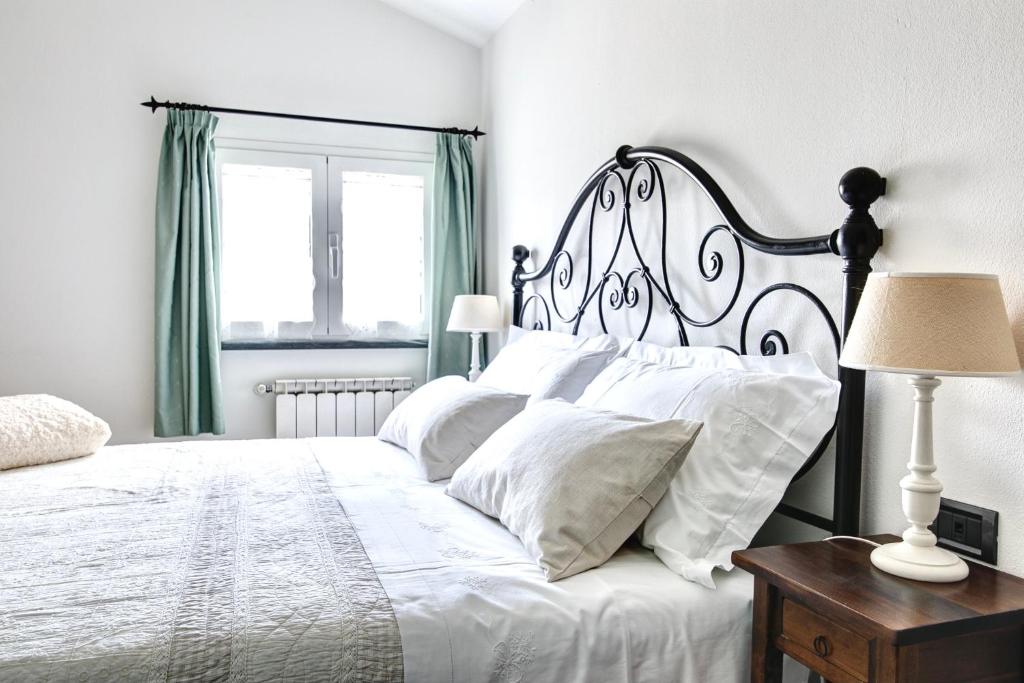 1 dormitorio blanco con 1 cama grande con almohadas blancas en A casa di Cinzia, en Forte dei Marmi