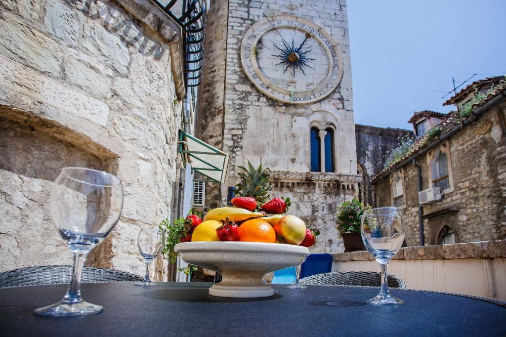 Miska owoców na stole z dwoma kieliszkami wina w obiekcie Villa Spaladium w Splicie