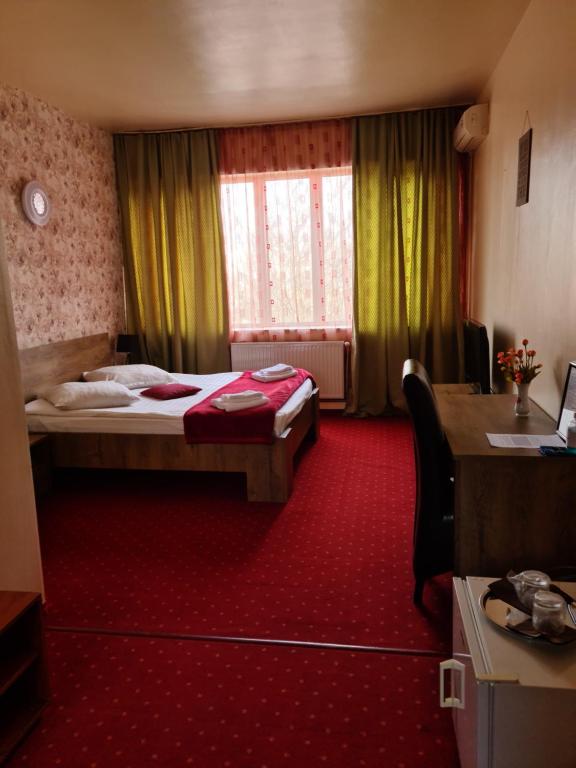 um quarto de hotel com duas camas e uma janela em Hotel Olimp em Cluj-Napoca