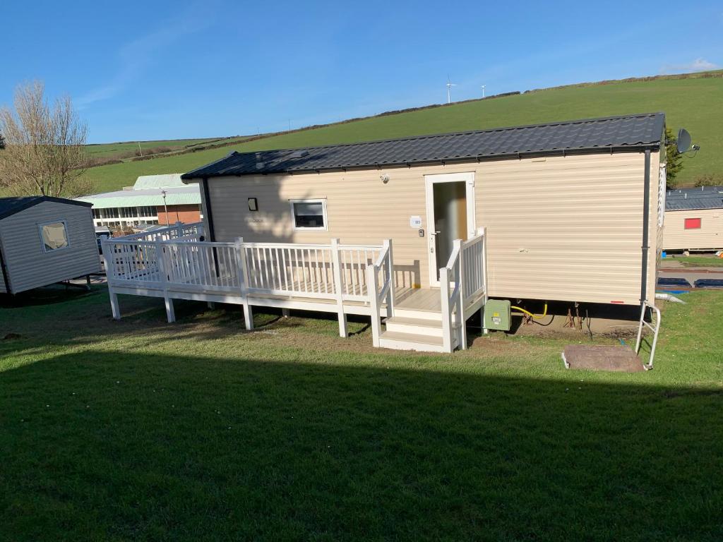 a small house with a porch and a deck at Newquay Bay in Newquay