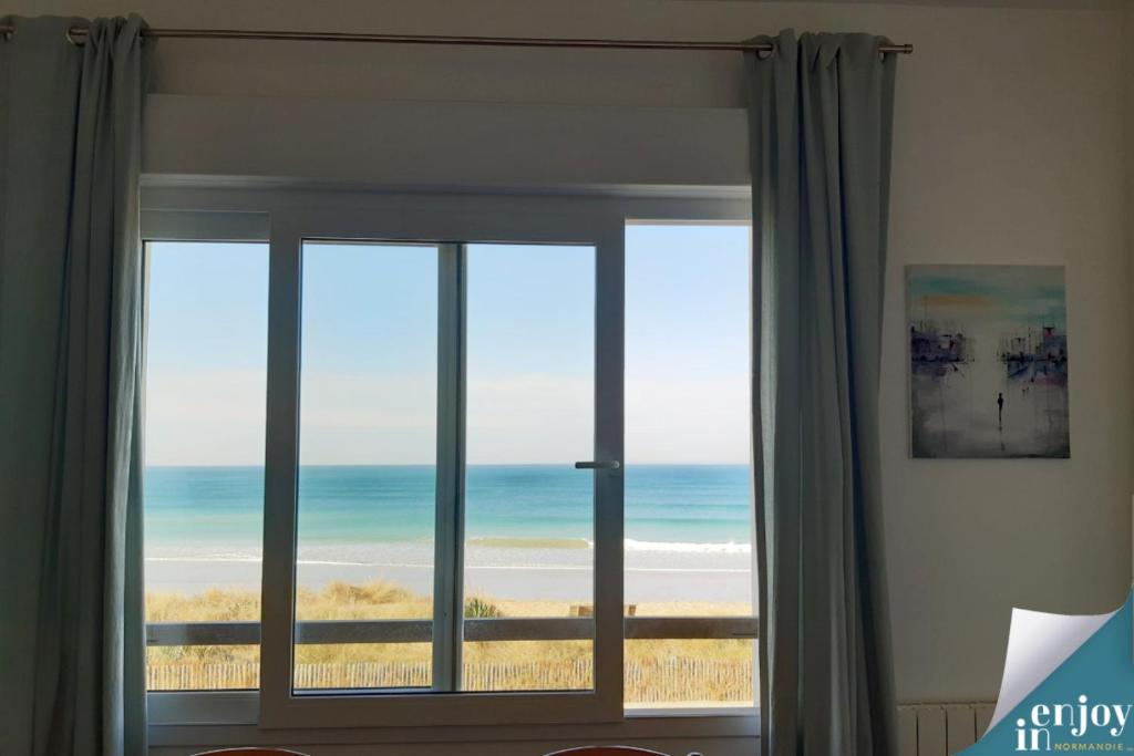 バルヌヴィル・カルトゥレにあるVilla Denise Grand Gîteの海の景色を望む窓付きの客室です。