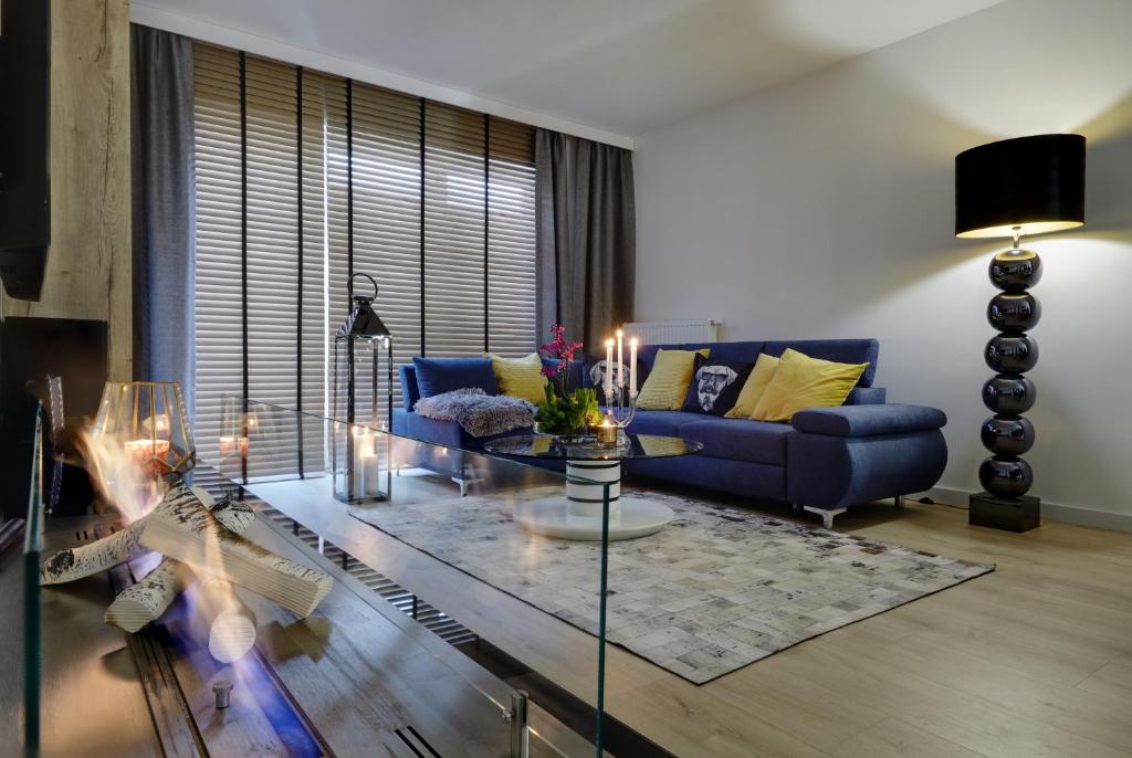 a living room with a blue couch and a glass table at Seven Heaven in Katowice