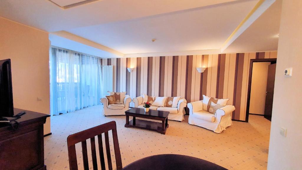 un soggiorno con divani bianchi e TV di Apartament 2706 Alpin Resort, etaj 7, Poiana Brașov a Poiana Brasov