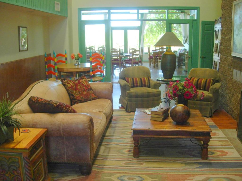 ein Wohnzimmer mit einem Sofa, Stühlen und einem Tisch in der Unterkunft Amado Territory B&B in Amado