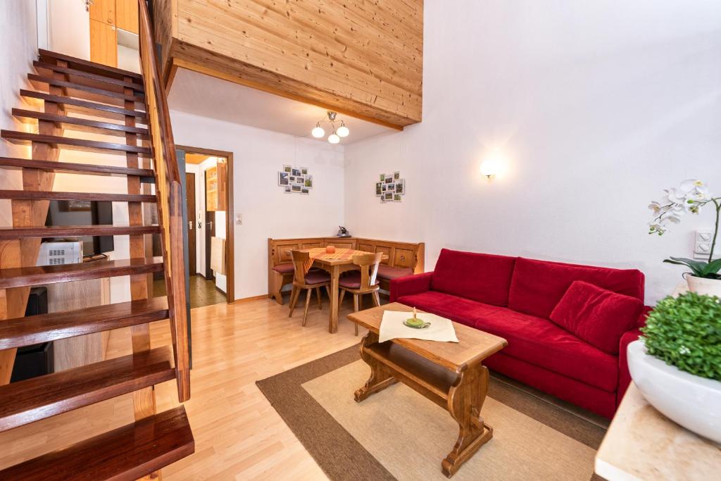 a living room with a red couch and a table at Imberg-Suite mit Schwimmbad in Oberstaufen