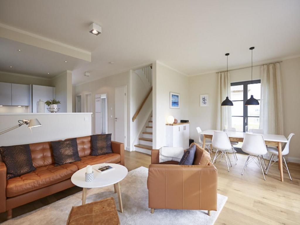 sala de estar con sofá y mesa en Reetland am Meer - Premium Reetdachvilla mit 3 Schlafzimmern, Sauna und Kamin E16, en Dranske