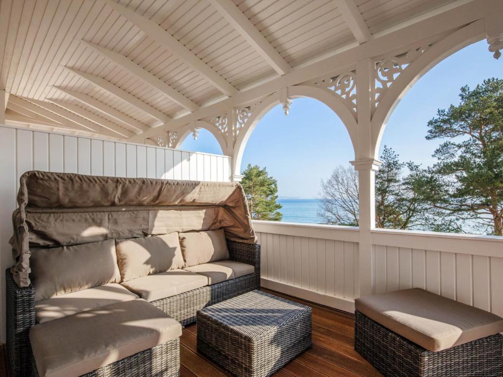 a screened in porch with a couch and a window at Strandvillen Binz - Ferienwohnung mit Meerblick, 2 Schlafzimmern und Balkon SV-008 in Binz