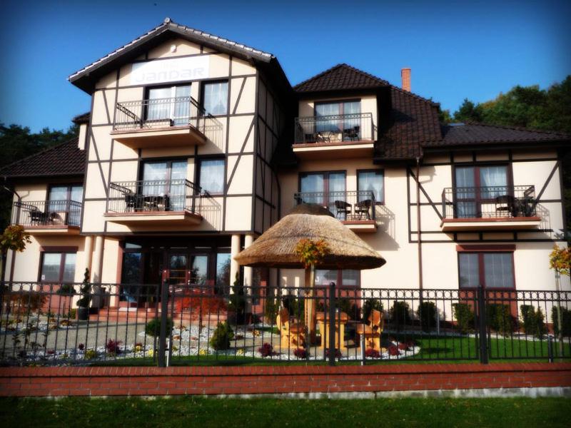 a large white house with a fence in front of it at Willa Jandar w Skowronkach in Kąty Rybackie