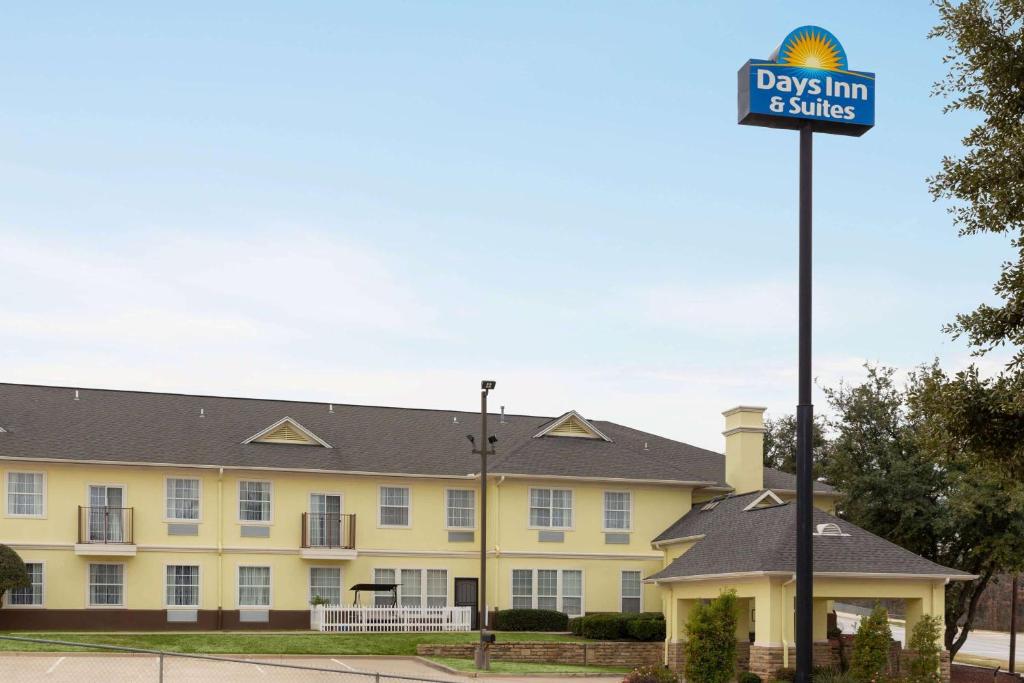 a street sign in front of a yellow building at Days Inn & Suites by Wyndham DFW Airport South-Euless in Euless