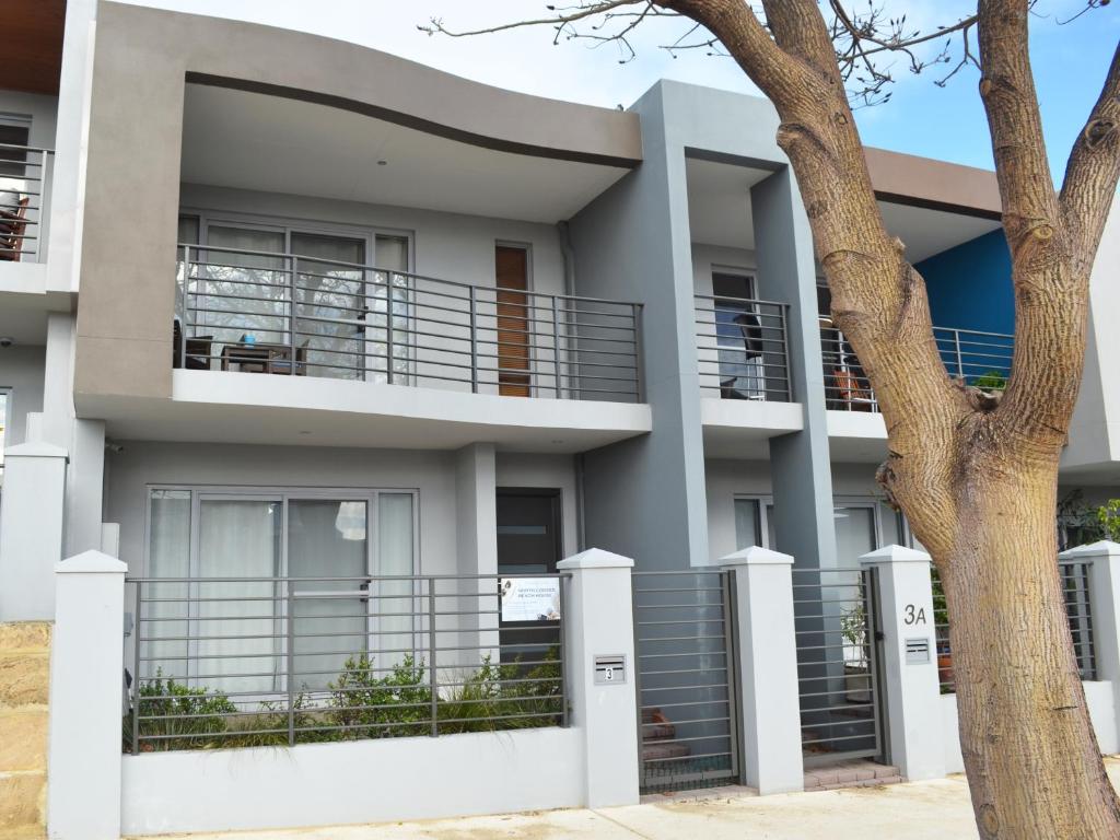 una casa con balcones y un árbol en North Coogee Beach House en Fremantle