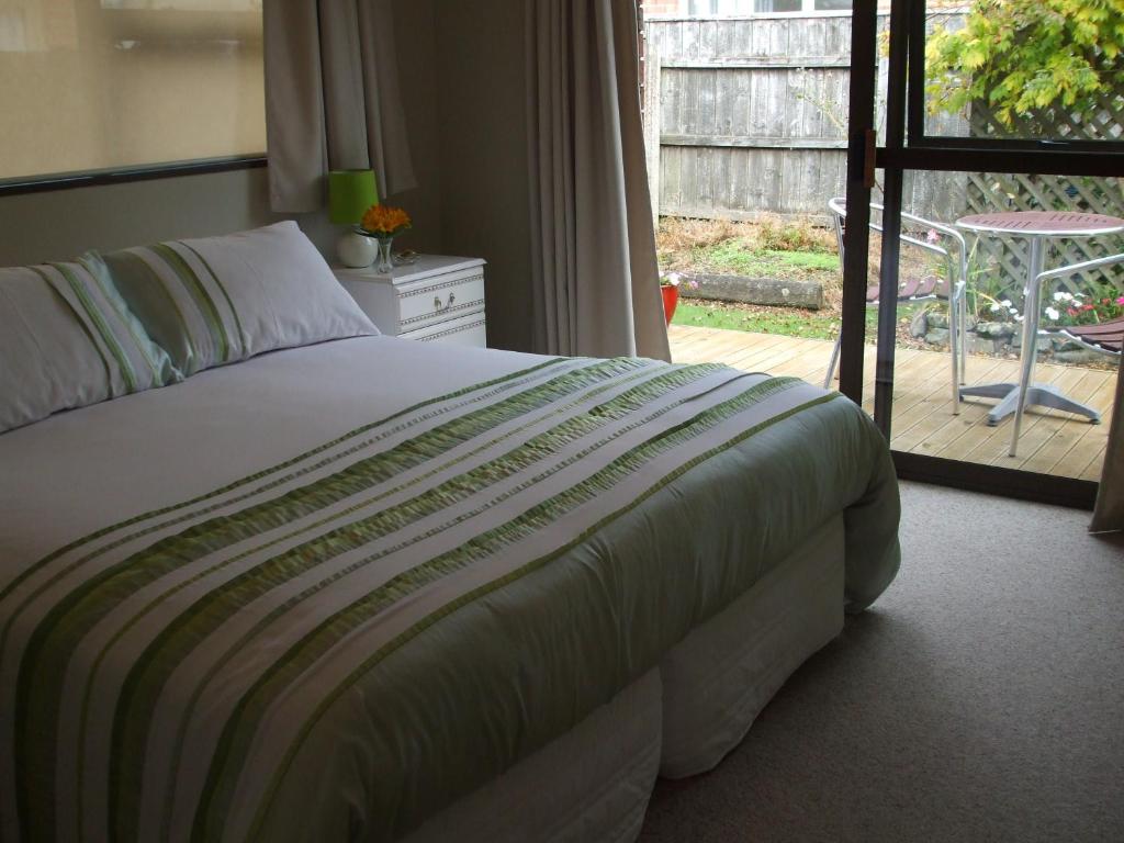a bedroom with a bed and a door to a patio at Havenlee Homestay in Westport
