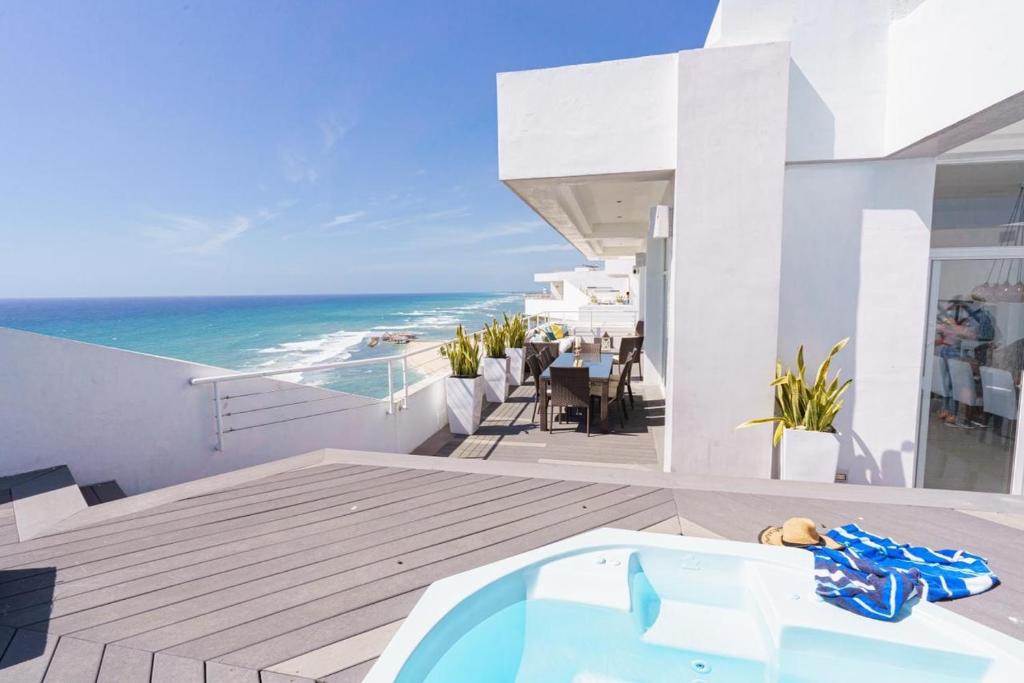 a bath tub sitting on top of a balcony with the ocean at Luxury penthouse portobello in Santo Domingo