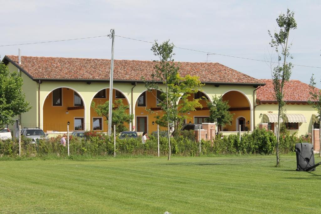 a yellow house with a yard in front of it at Agriturismo Nonna Rina in San Liberale