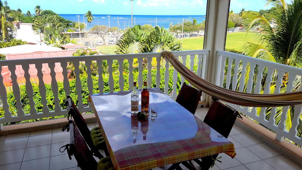 una mesa y una silla en un balcón con vistas al océano en Les pieds dans l'eau, en Tartane