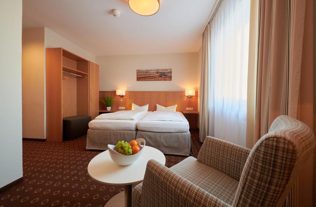 ein Hotelzimmer mit einem Bett, einem Tisch und Stühlen in der Unterkunft Inntalhof in Kirchdorf am Inn