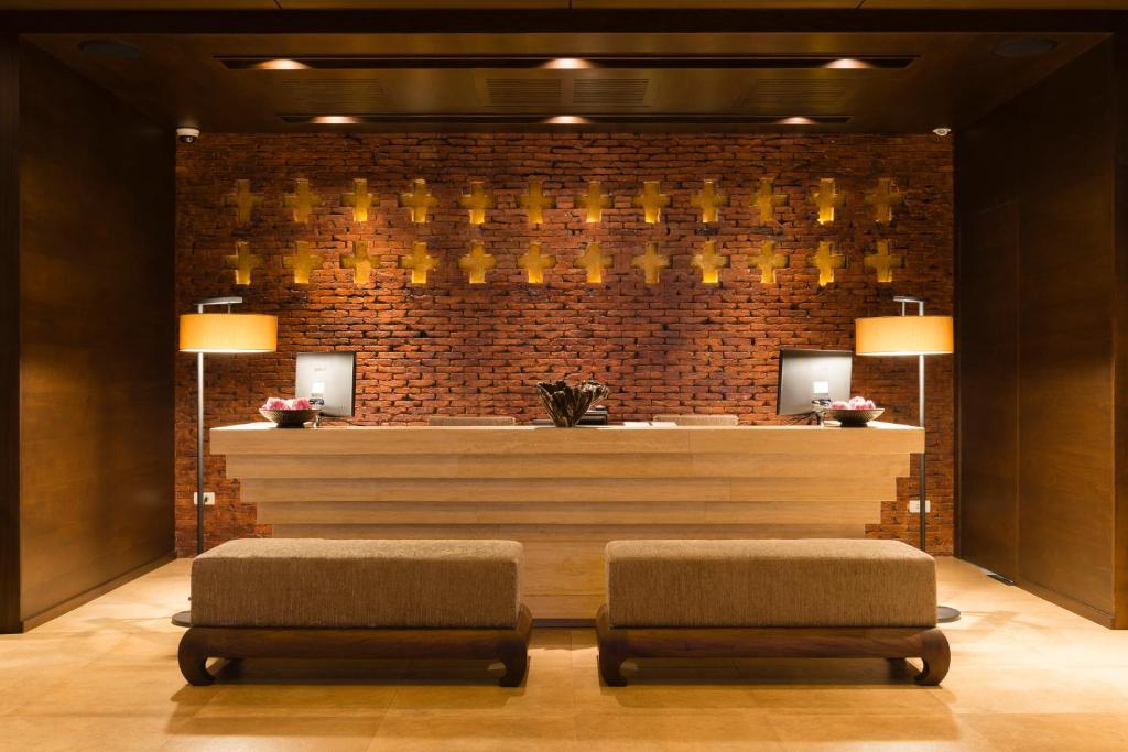 A compact reception area with two benches facing a warmly lit desk.