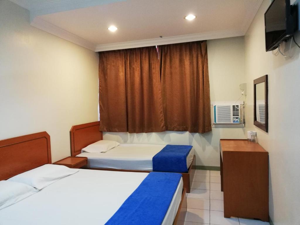 a hotel room with two beds and a window at Sri Gate Hotel in Dungun