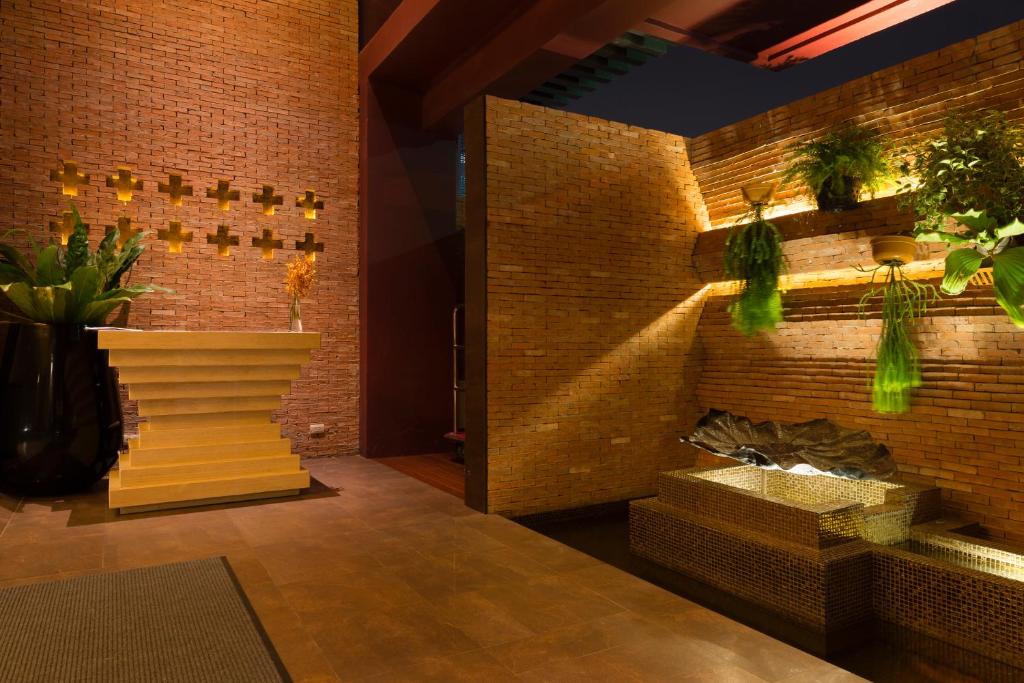 A brick-lined lobby feature area with a sculptural fireplace and planted shelving.