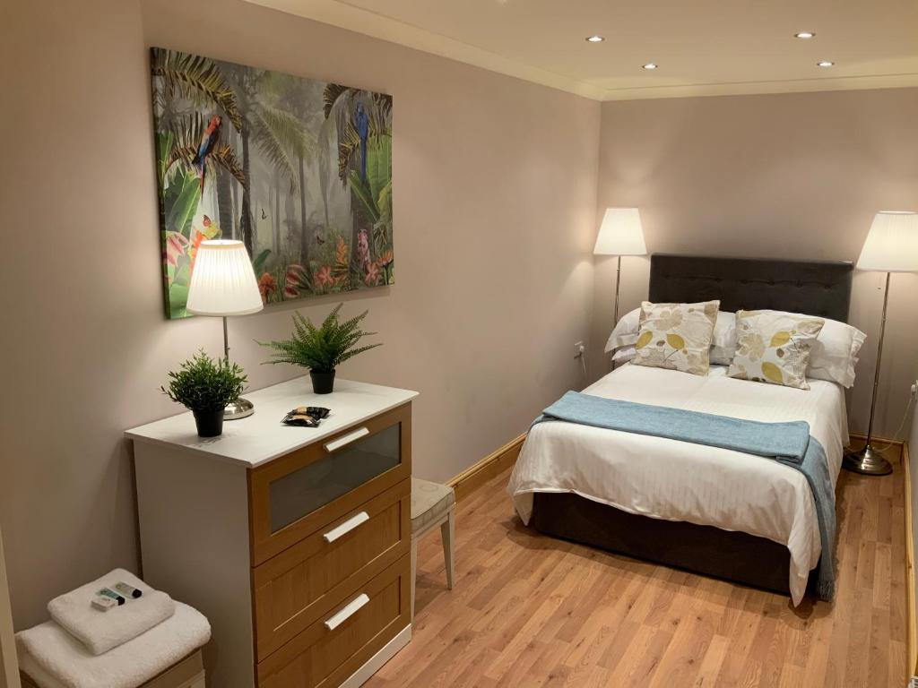 a bedroom with a bed and a painting on the wall at Dove Cottage (Annex) in Workington